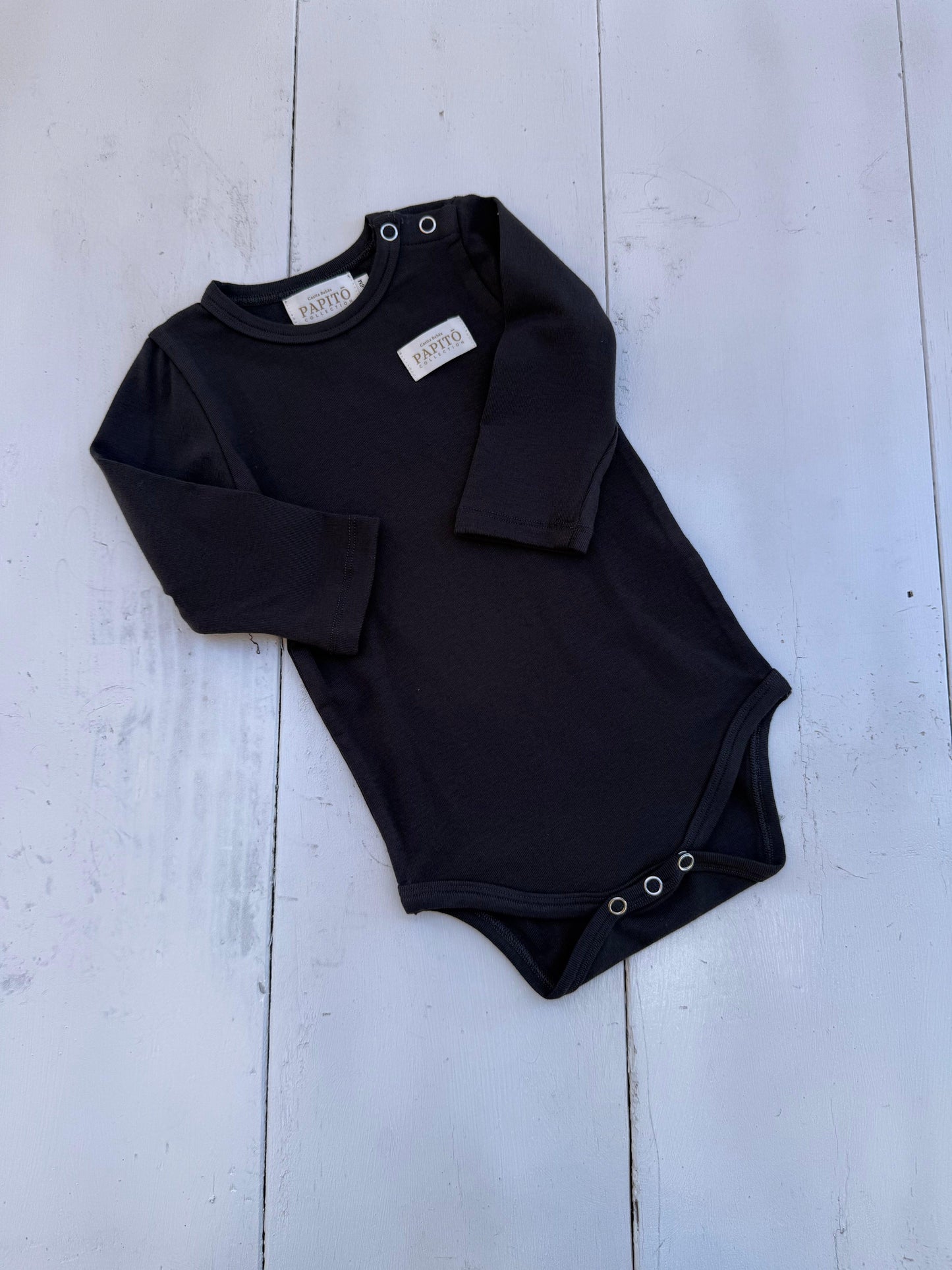 Dusty black organic cotton bodysuit with snap closures, certified organic baby clothing.