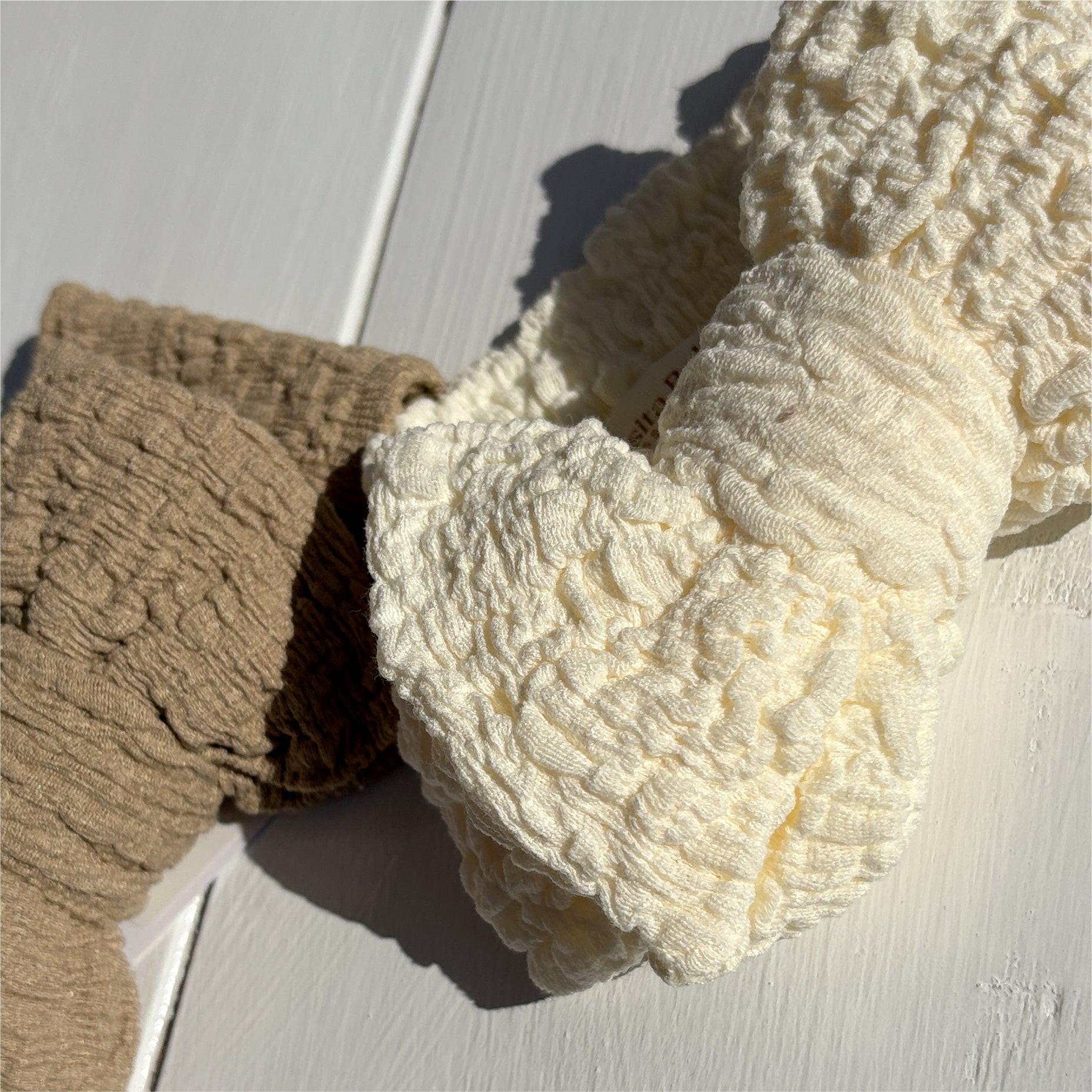 Certified organic textured baby bow in dusty white and dusty khaki, soft organic baby clothing accessory by Casita Bebes.